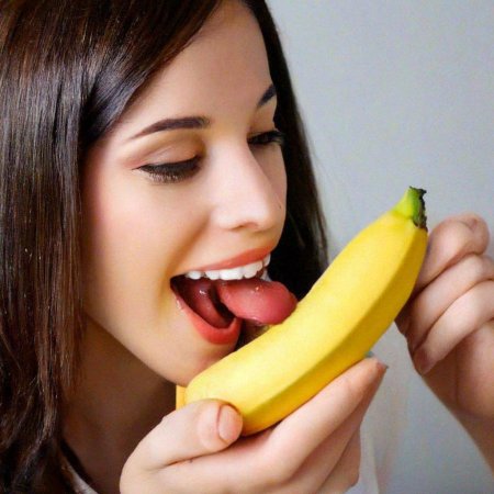 Девушка ест банан