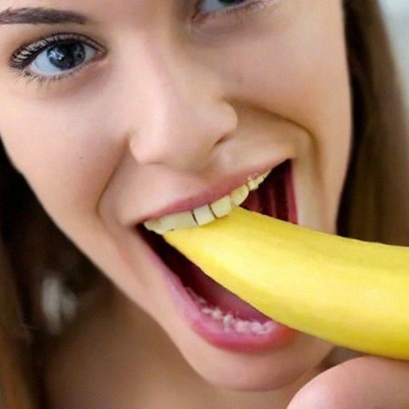 Девушка ест банан