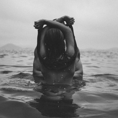 Девушка в воде со спины