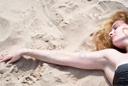 Девочка лежит на песке