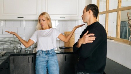 Муж и жена ругаются в квартире с бумагами в руках