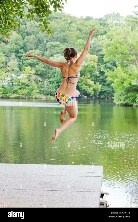 Девушка прыгает в речку