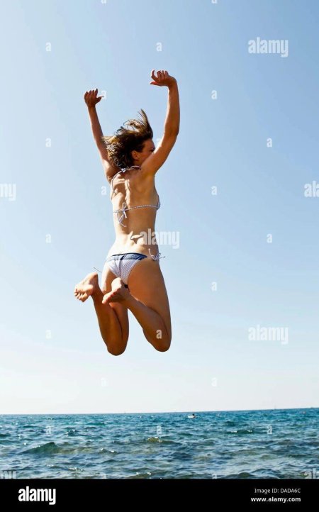 Девушка прыгает в море