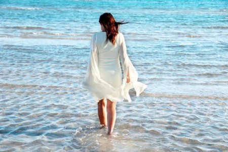 Девушка идет по берегу моря