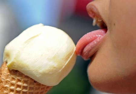 Облизывает мороженое