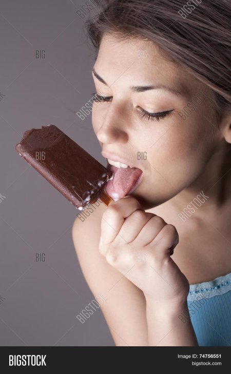 Девушка облизывает мороженое