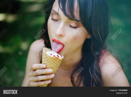 Девушка облизывает мороженое