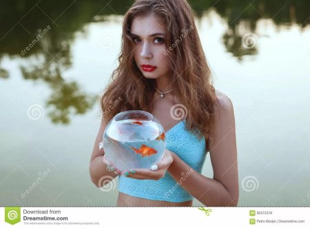 Девушка держит аквариум в руках