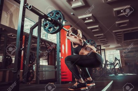 Девушка приседает в зале