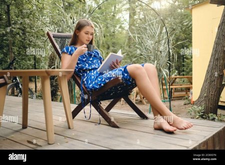 Девушка в платье босиком на диване