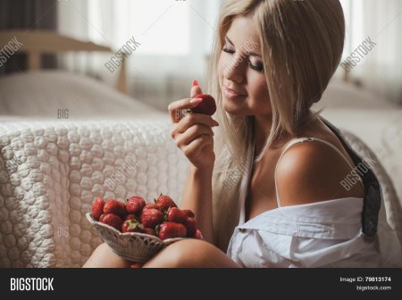 Девушка на кровати с клубникой