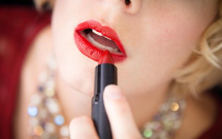 Девушка красит губы