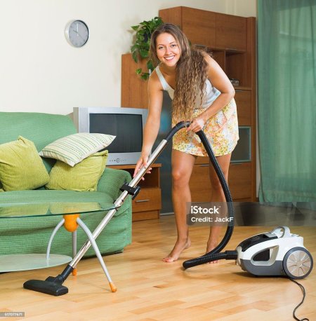 Женщина пылесосит