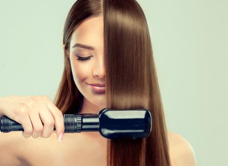 Девушка выпрямляет волосы