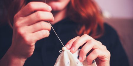 Девушка шьет руками