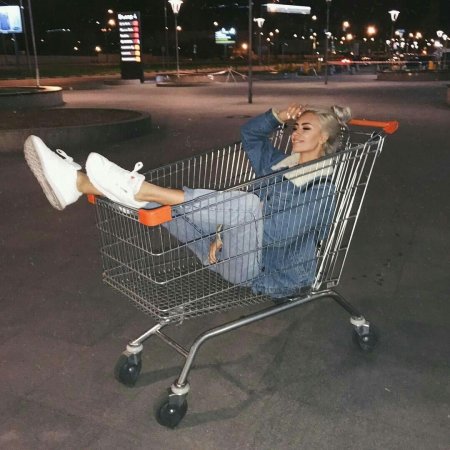Девушка в тележке с супермаркета