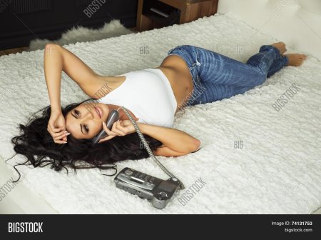 Девушка лежа говорит по телефону