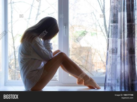 Девушка плачет у окна