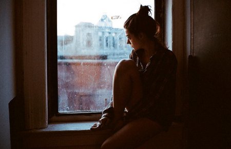Грустная женщина у окна