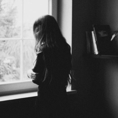 Девушка у окна со спины