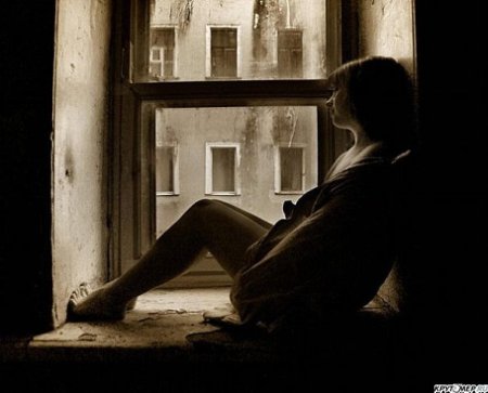 Девушка грустит у окна