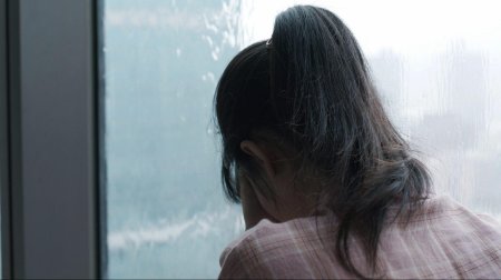 Женщина плачет у окна