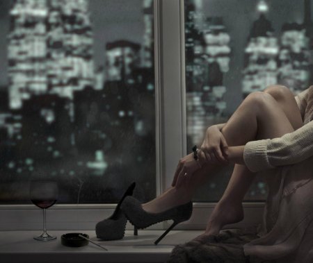 Девушка сидит у окна