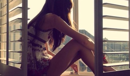 Девушка сидит на подоконнике