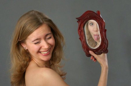 Женщина смотрится в зеркало