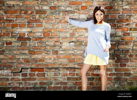 Девушка на фоне кирпичной стены