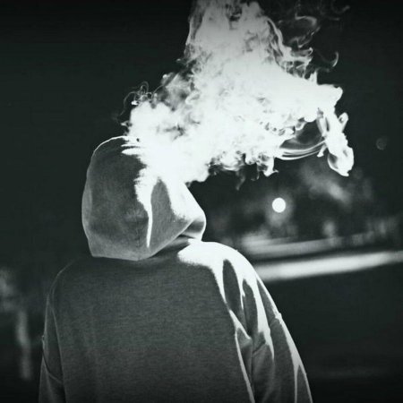 Курящий человек в капюшоне