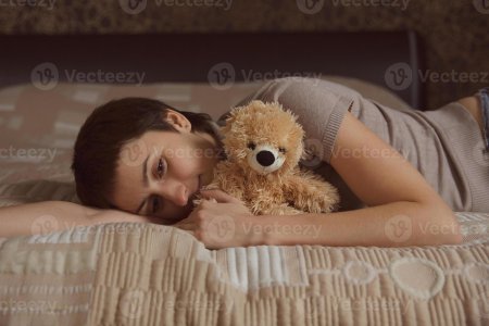 Девушка в постели с мишкой