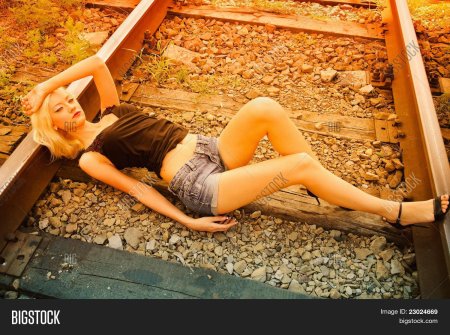 Девушка лежит на рельсах