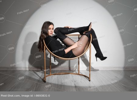 Девушка сидит в черном трико