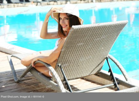 Девушка на шезлонге у бассейна