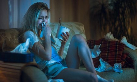 Девушка плачет на диване