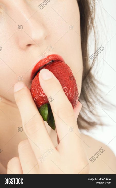 Брюнетка ест клубнику