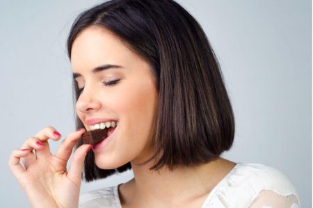 Девушка ест шоколад