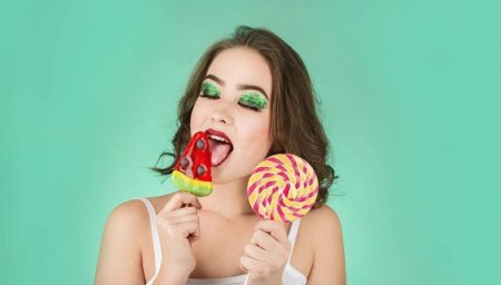 Девушка облизывает мороженое