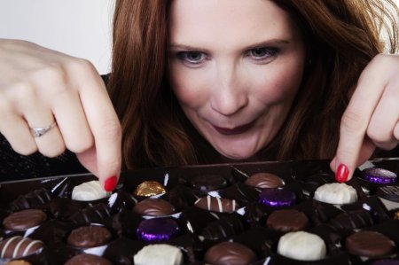 Девушка ест конфеты