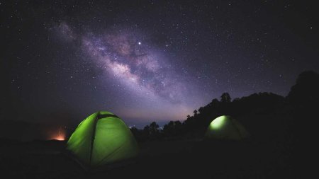 Зеленая палатка на фоне звездного неба