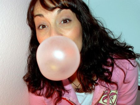 Девушка надувает жвачку