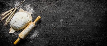 Тесто и скалка на черном фоне