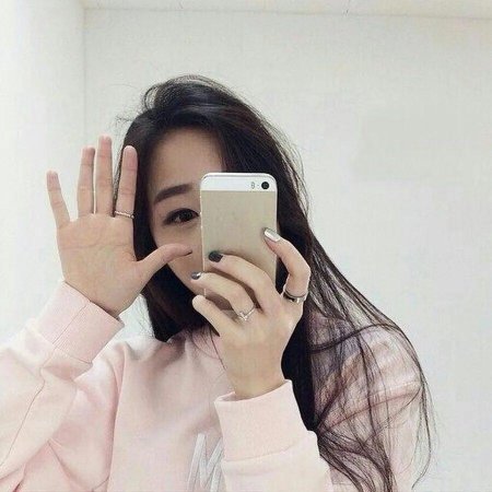 Девушка закрывает лицо телефоном