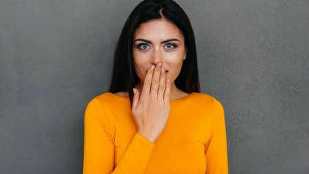 Девушка прикрывает рот рукой