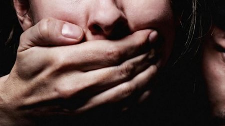 Закрывает рот рукой