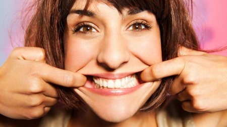 Женщина показывает зубы
