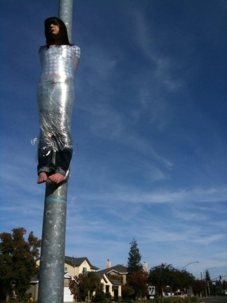 Девушка привязана к столбу