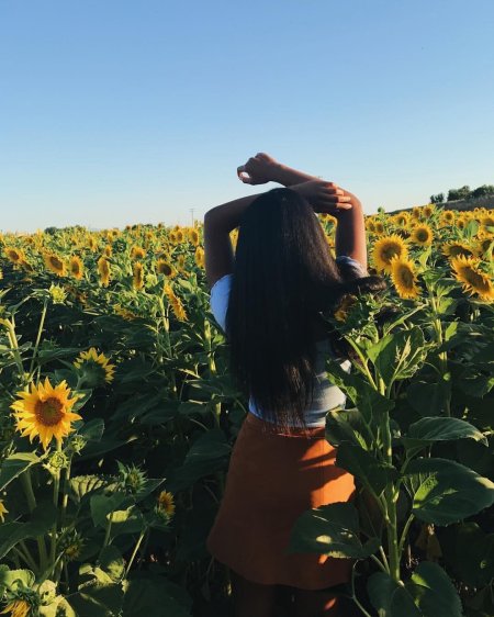 Девушка в поле со спины