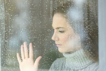 Женщина смотрит в окно фото